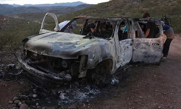 Members of the LeBarón family search through the burned car where five of the nine Mormon community members were killed in an ambush launched by a cartel gang in Bavispe, Sonora, on November 4, 2019